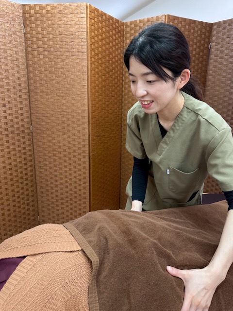 Linareの施術風景。女性スタッフが笑顔で施術を行っています